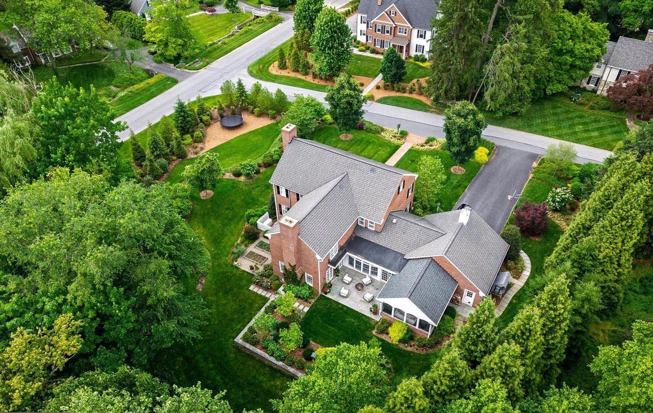 Aerial view of the house, its roof, rear terrace and tree-lined grounds